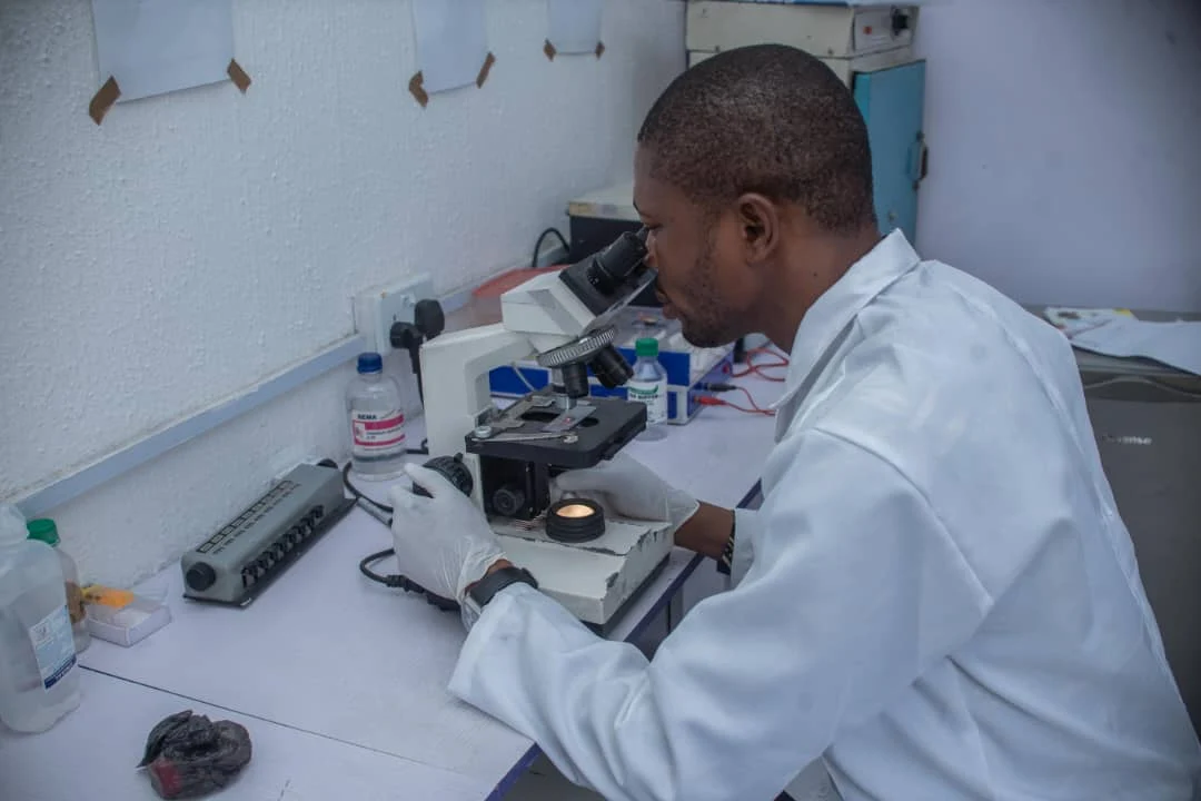 Laboratory professional using a microscope at the diagnostic facility
